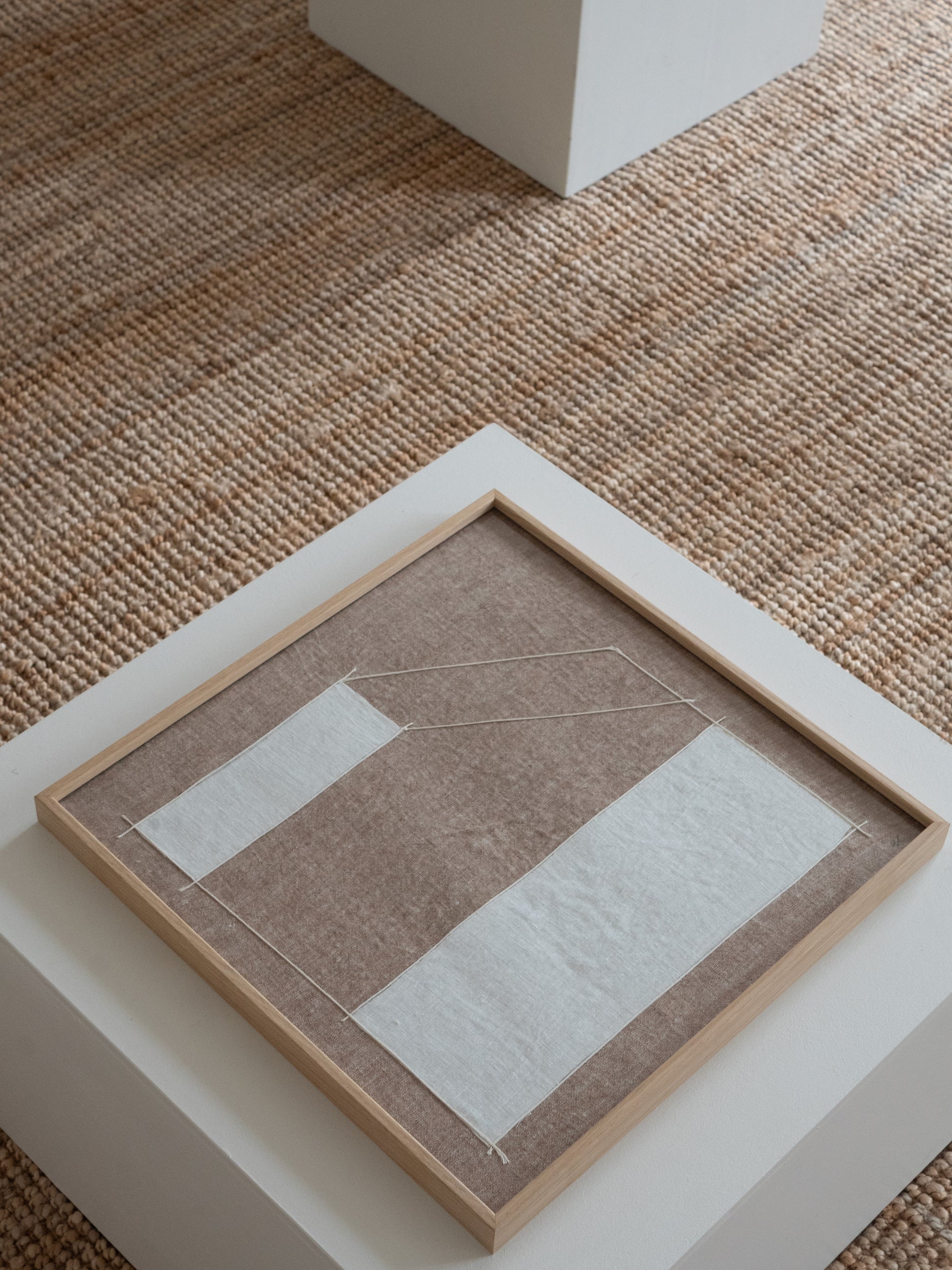 Abstract textile wall artwork made from natural linen with structured graphic lines in neutral tones.