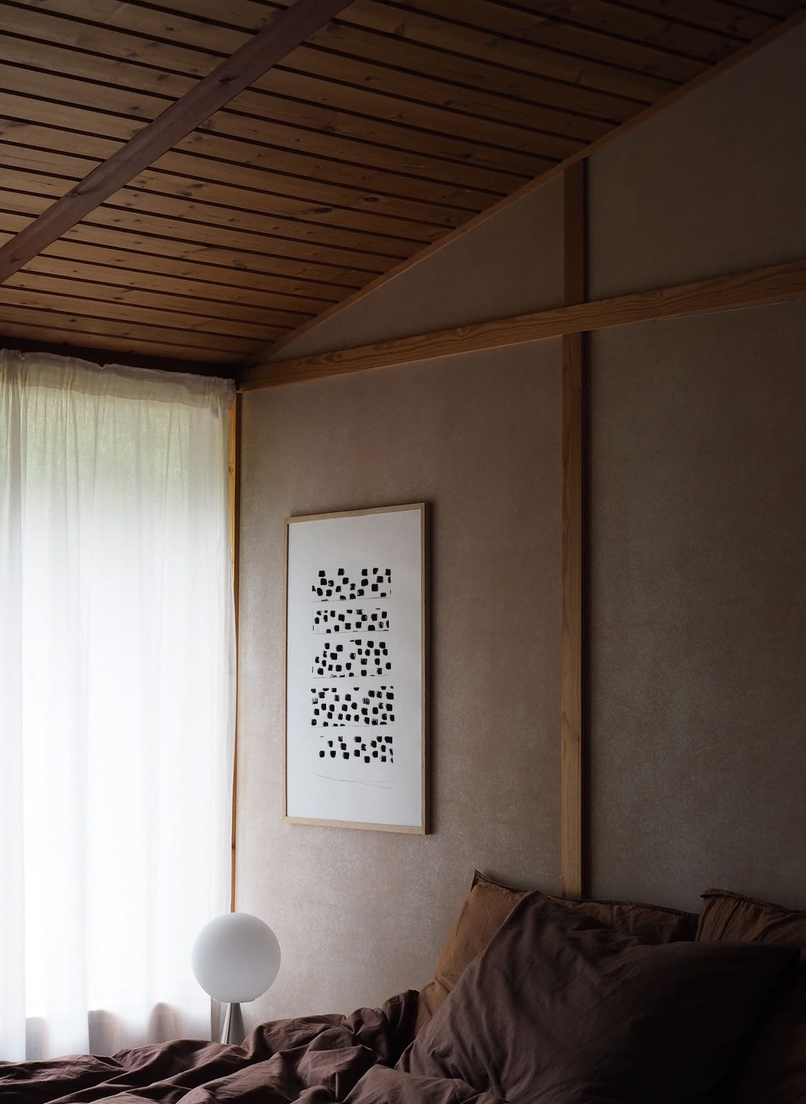 White poster with black dots hanging in a bedroom by Atelier Cph