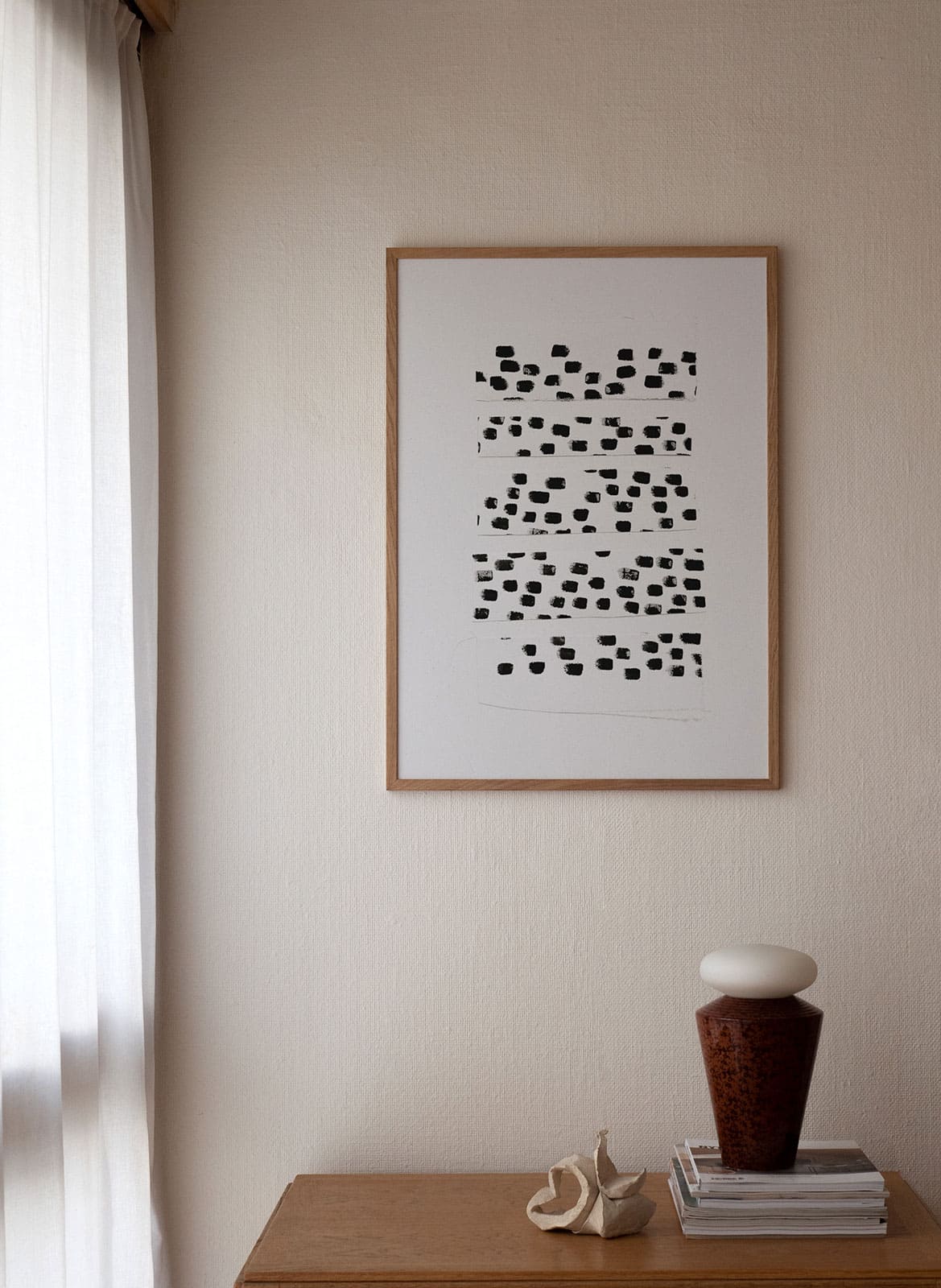 White poster with black dots hanging above a table by Atelier Cph