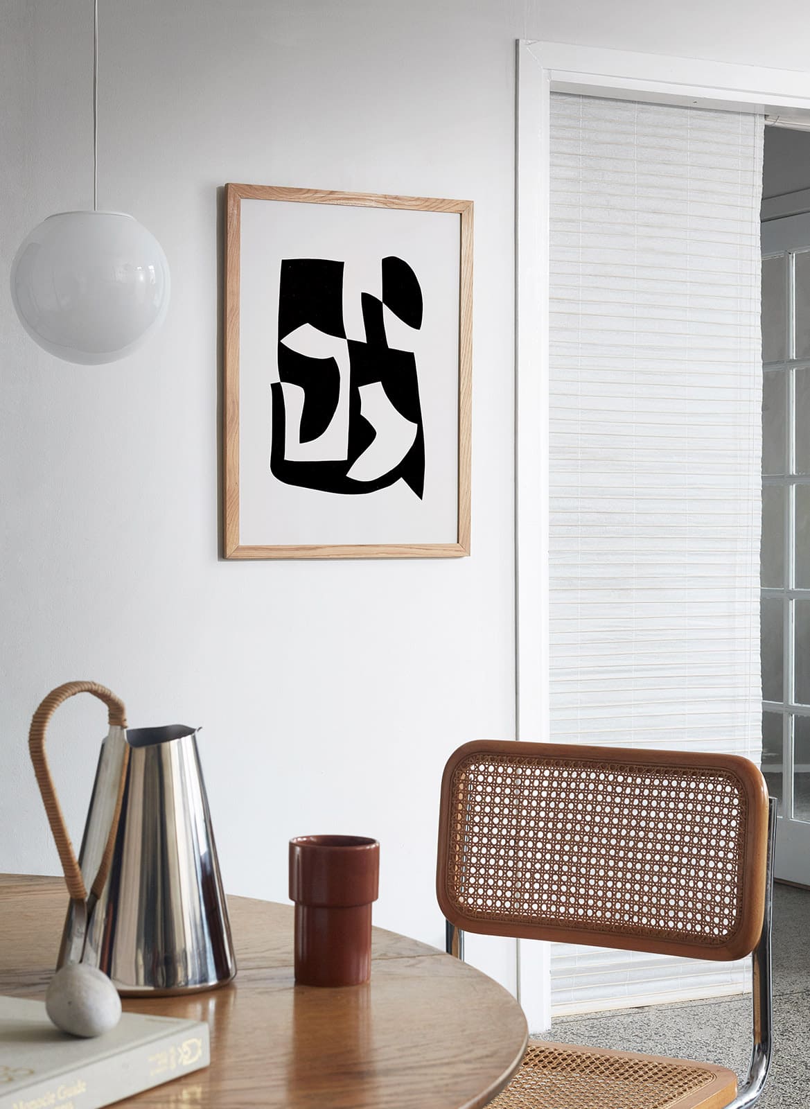  Framed black and white poster hanging above dining table by Atelier Cph