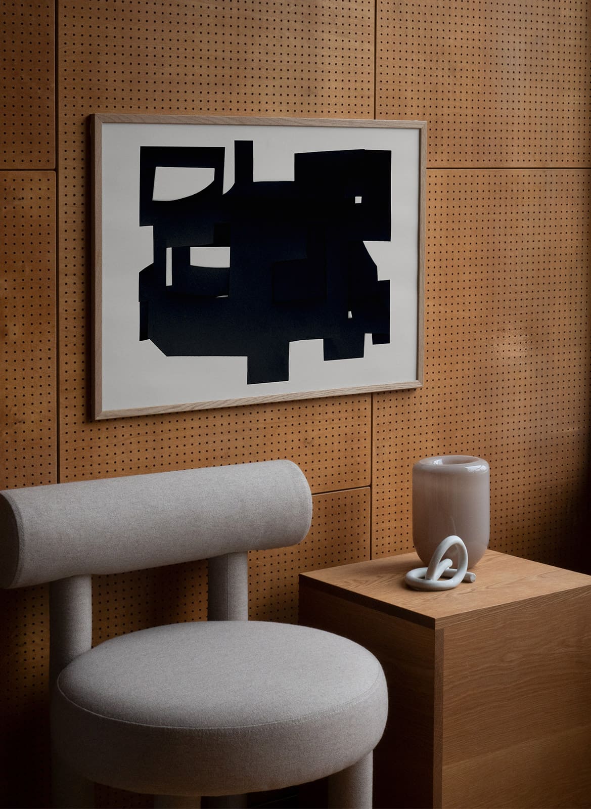 Framed abstract poster hanging above a chair by atelier cph