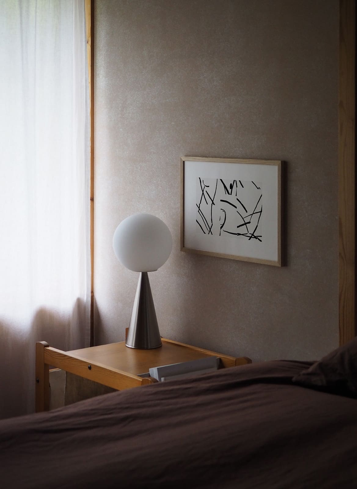 Framed minimalistic poster with lines hanging in a bedroom by atelier cph