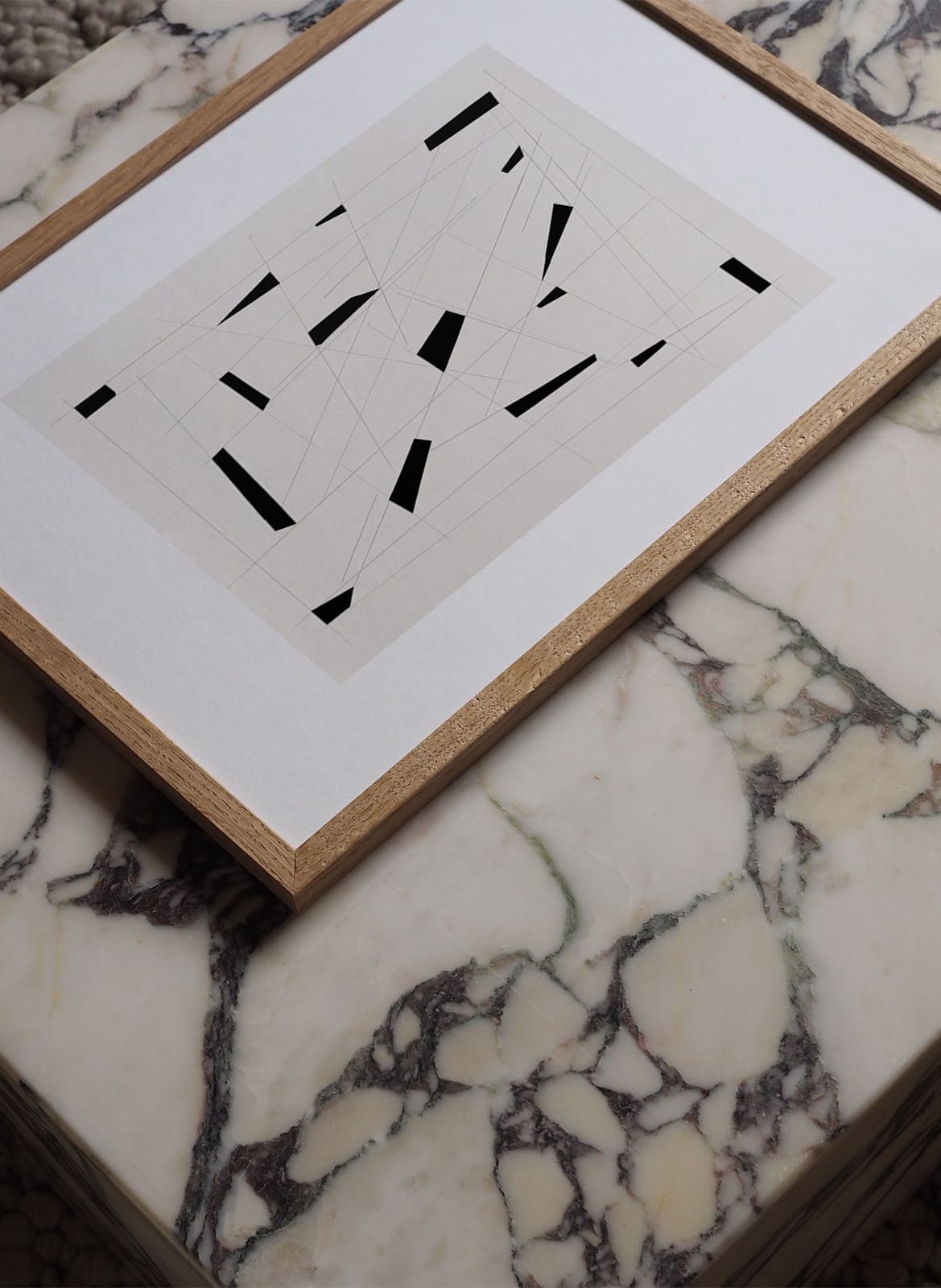 Framed graphic poster laying on a marble by atelier cph