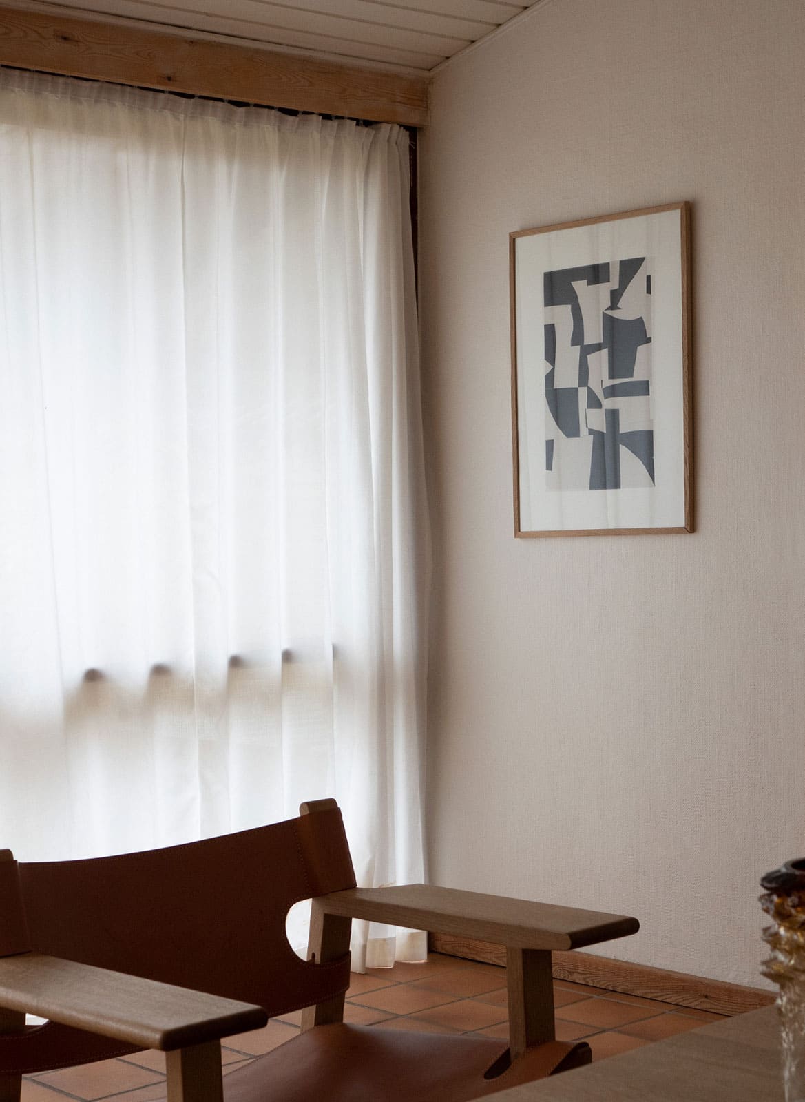 Framed black and white poster hanging in a living room by atelier cph