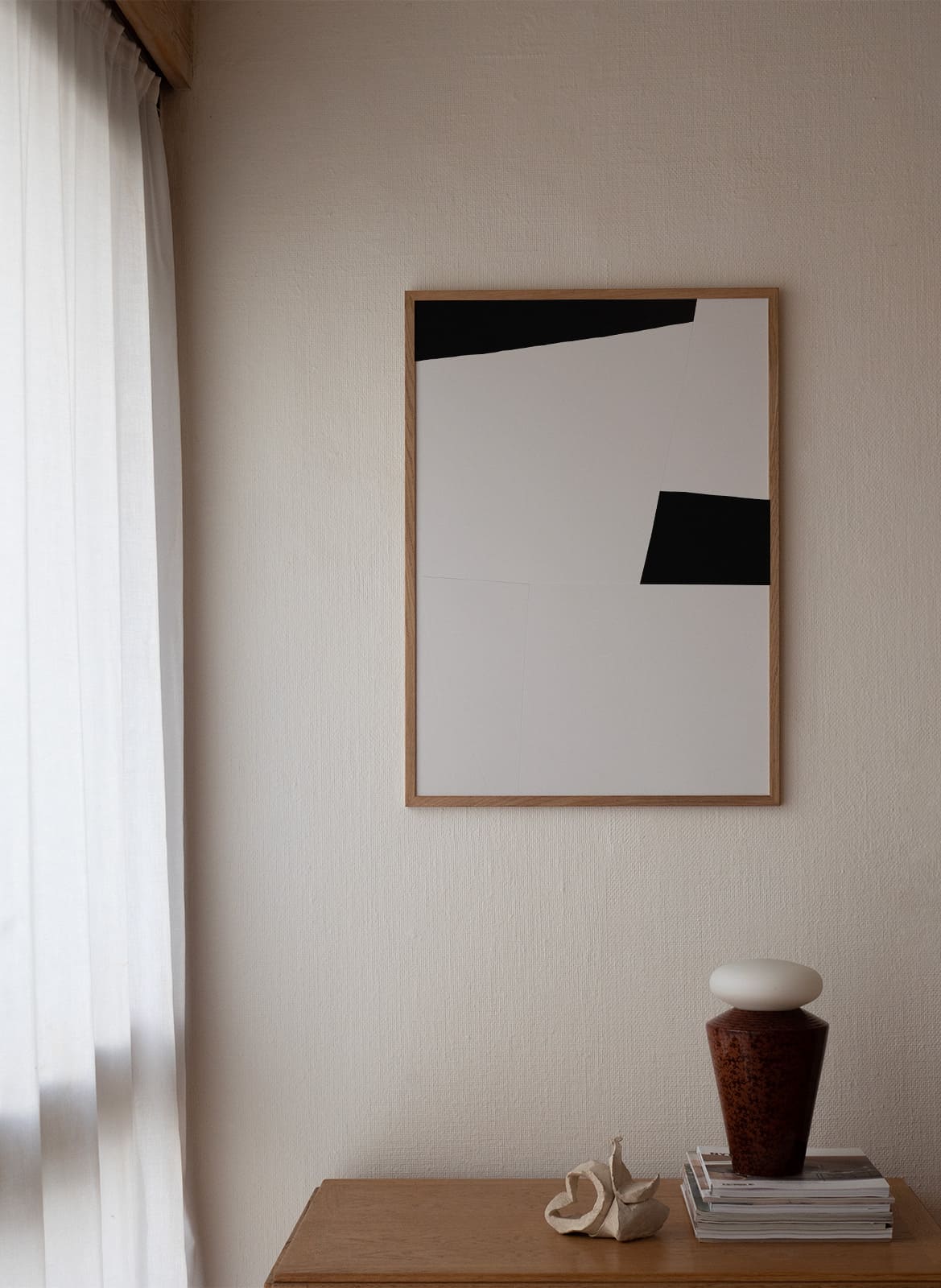 Framed minimalistic poster hanging in a living room by atelier cph