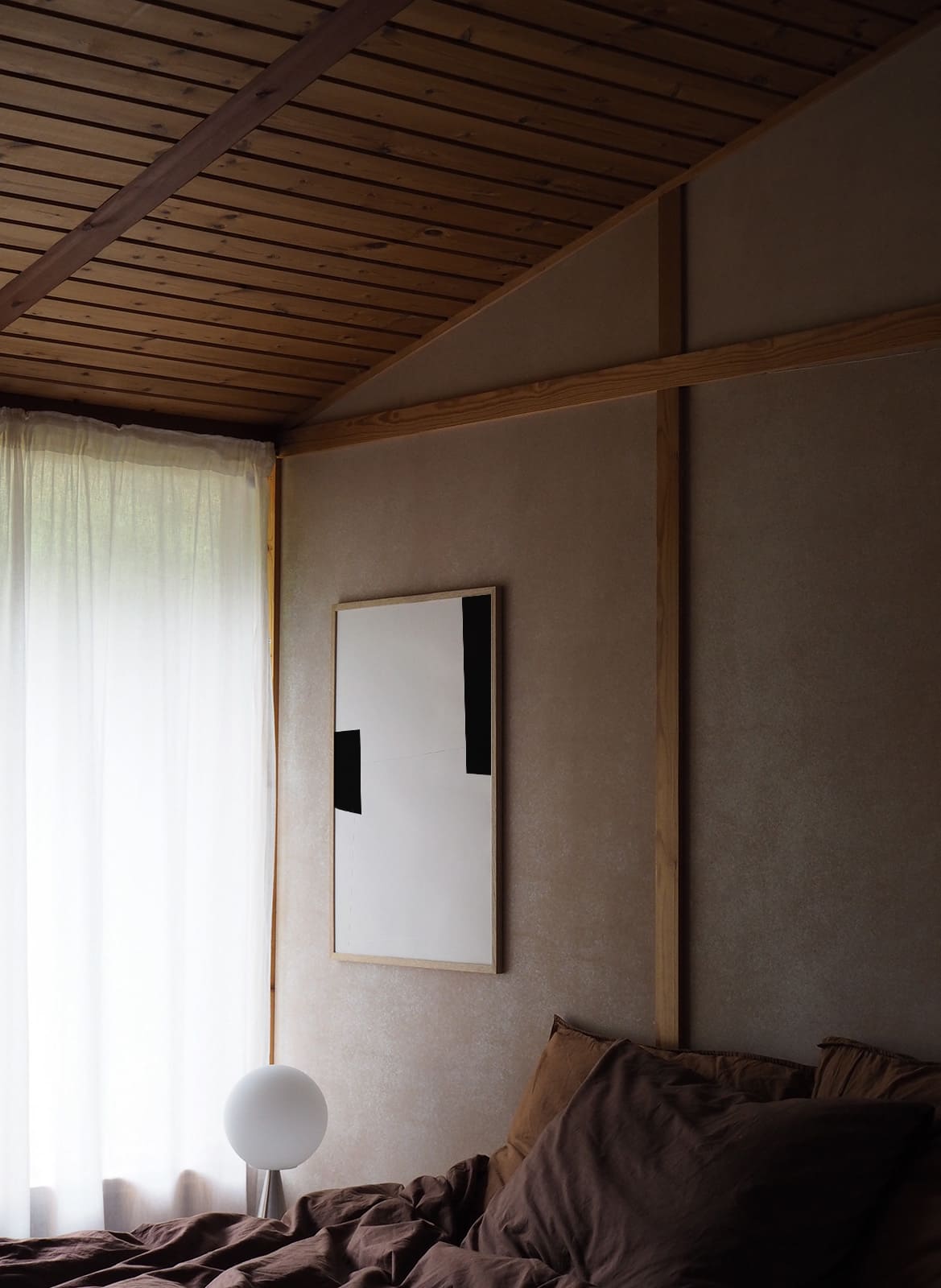 Framed minimalistic poster hanging in a bedroom by atelier cph