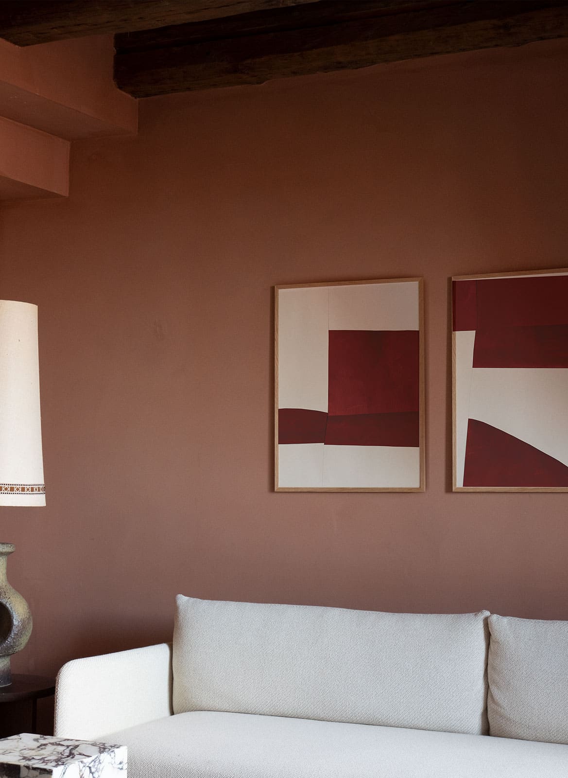 2 framed minimalistic red posters hanging above a couch by atelier cph