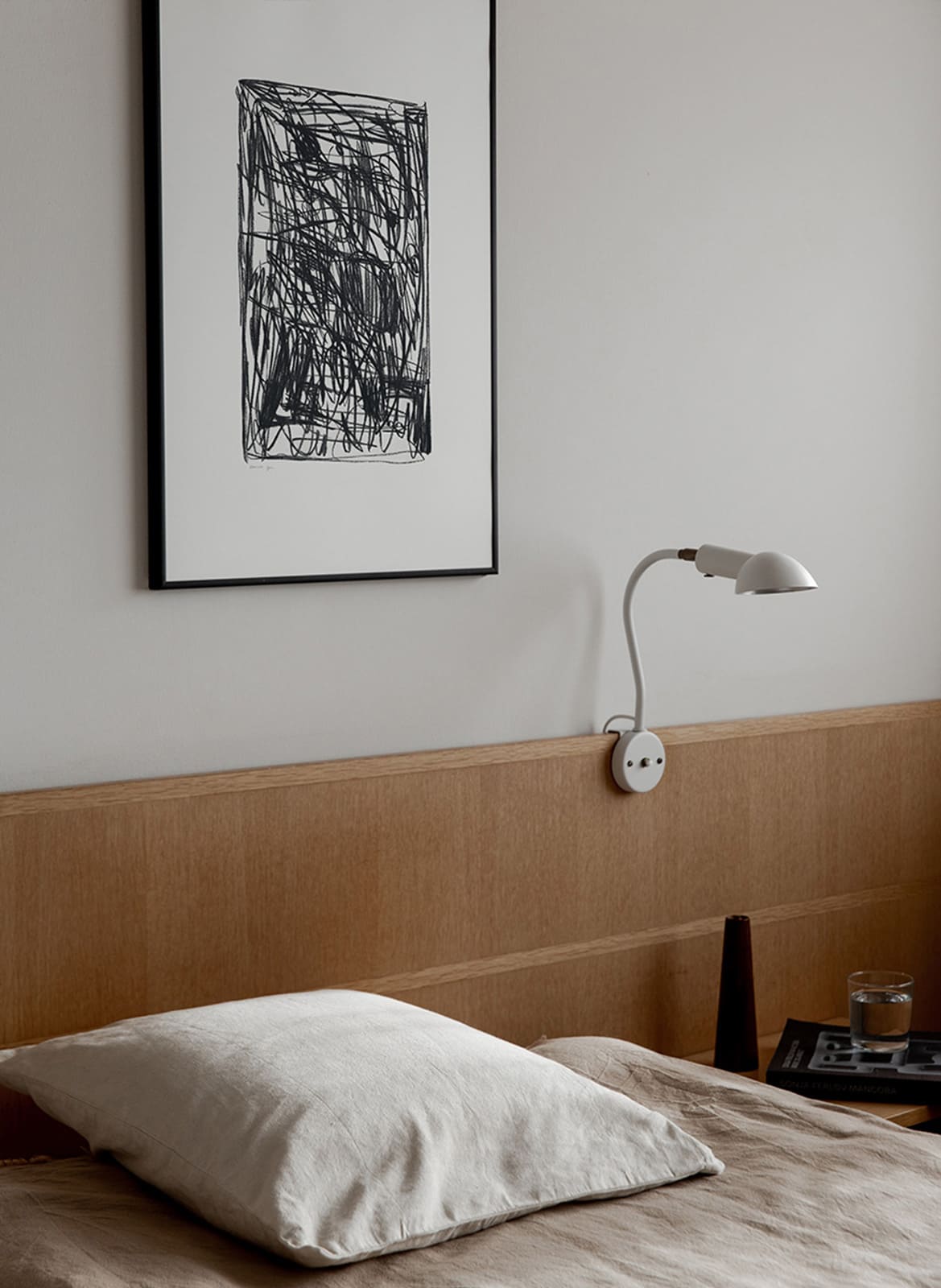 Framed minimalistic poster hanging above a bed by Atelier Cph