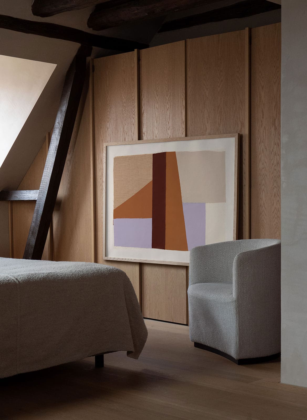 Framed colourful posters hanging in a bedroom by Atelier Cph