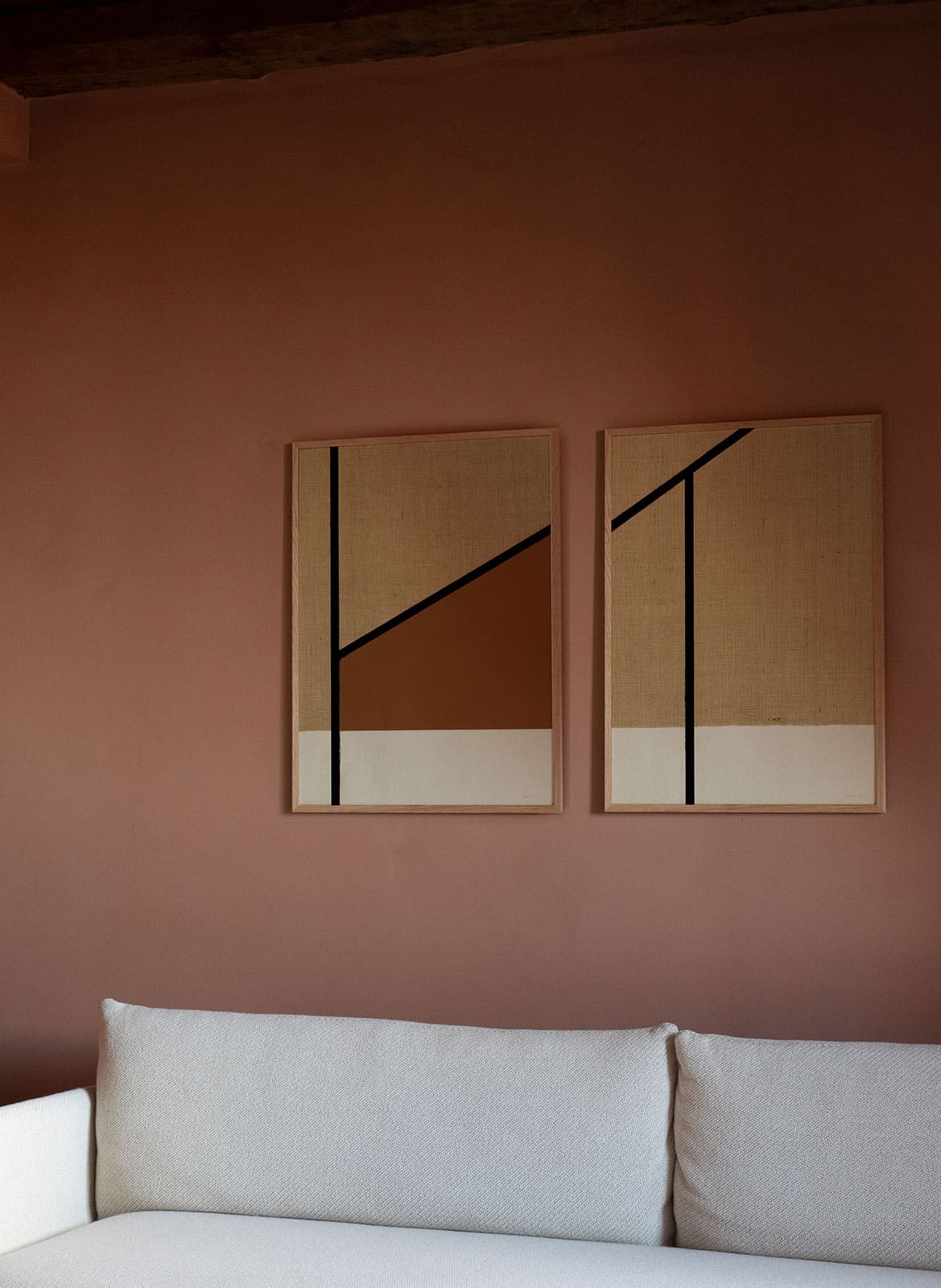 Framed graphic posters hanging above a couch by atelier cph