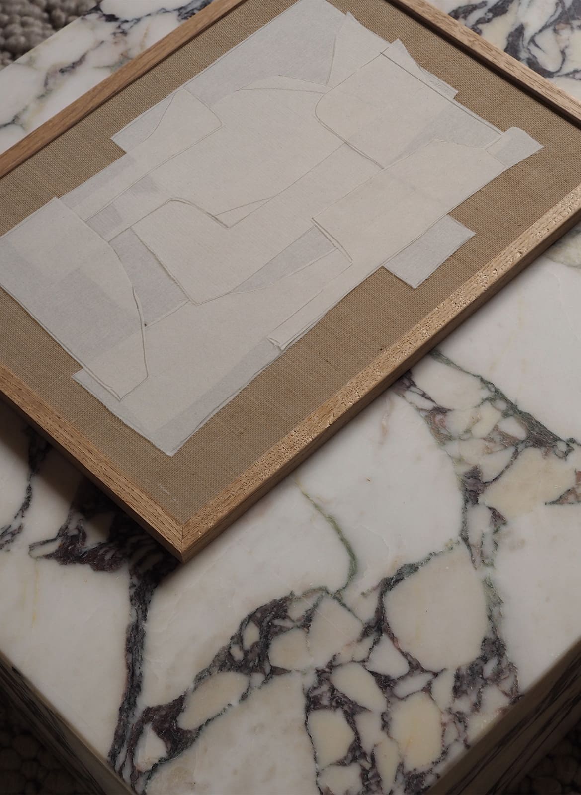 Framed abstract poster laying on a marble table by Atelier Cph