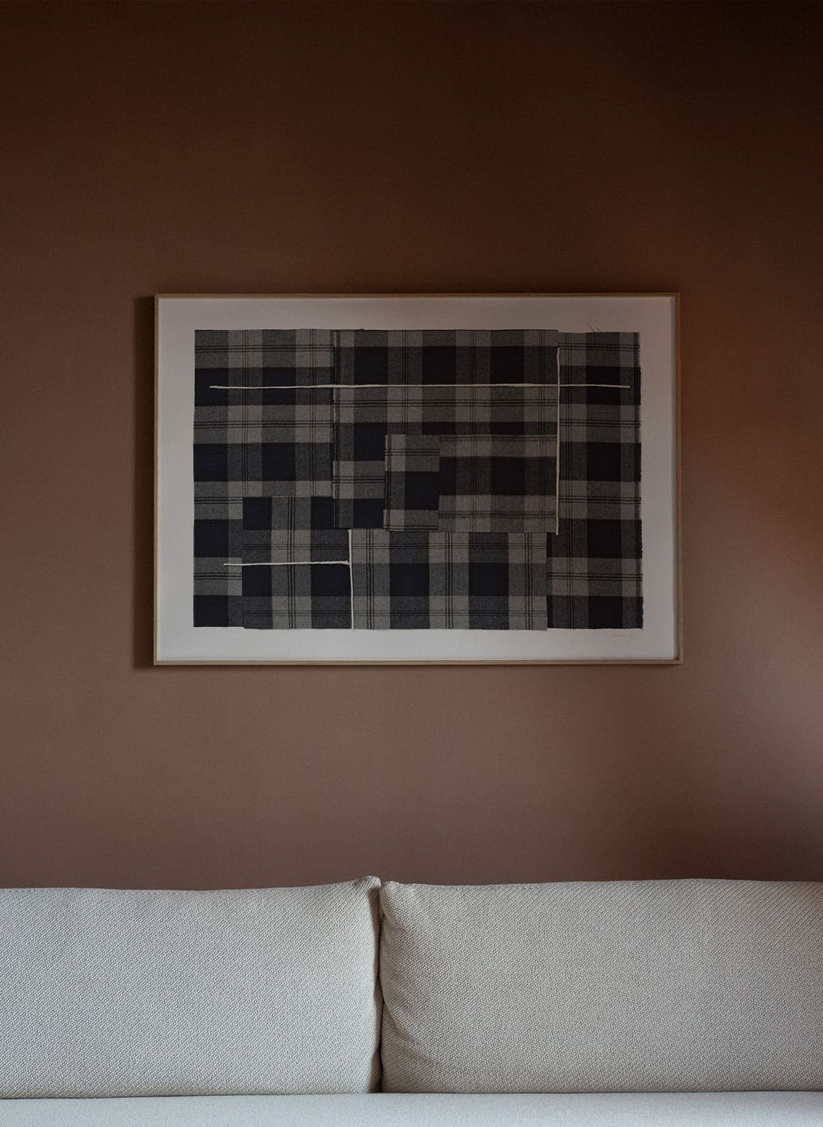 Checked black and white poster hanging above a couch table by atelier cph