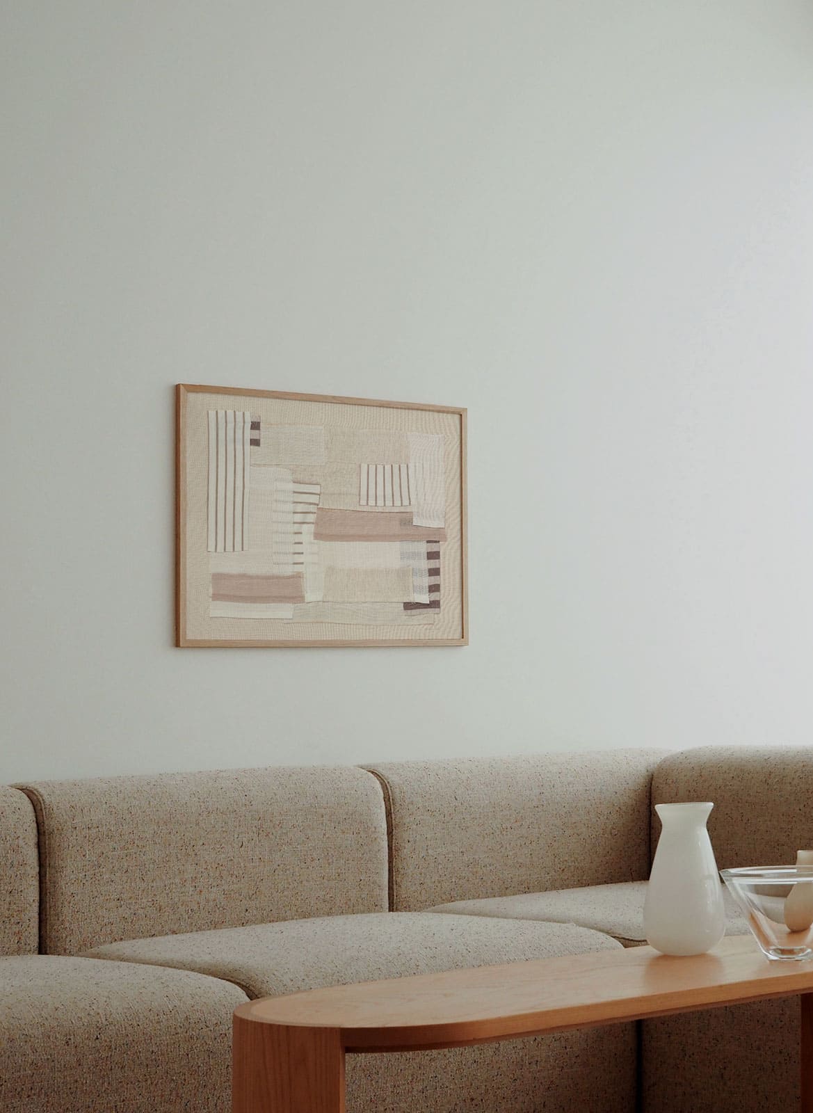 Framed striped poster hanging above a couch by Atelier Cph