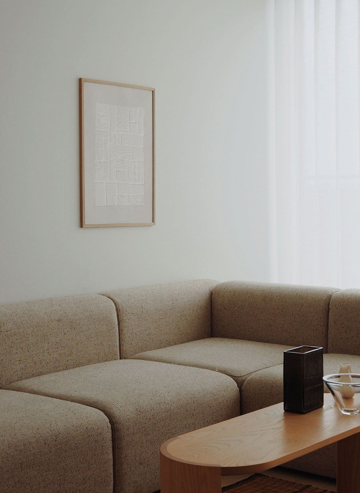 Framed minimalistic poster hanging above a couch by Atelier Cph