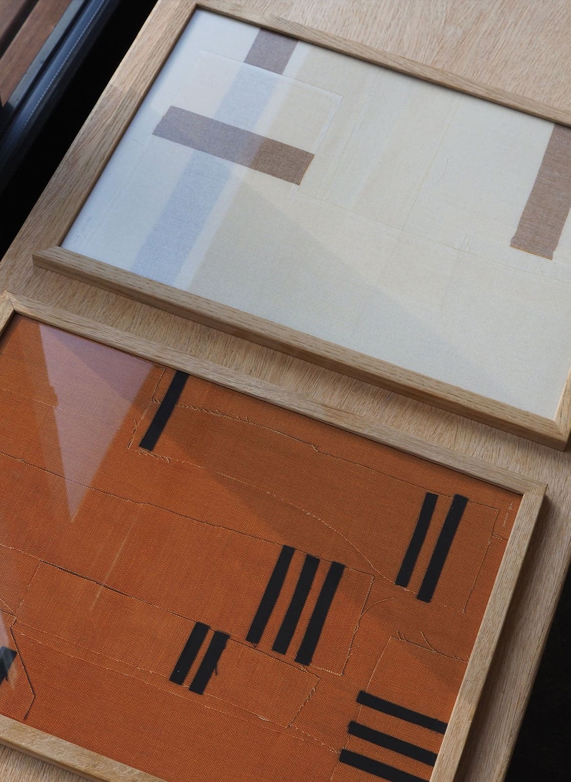 2 framed art pieces laying on a wooden bench by Atelier Cph