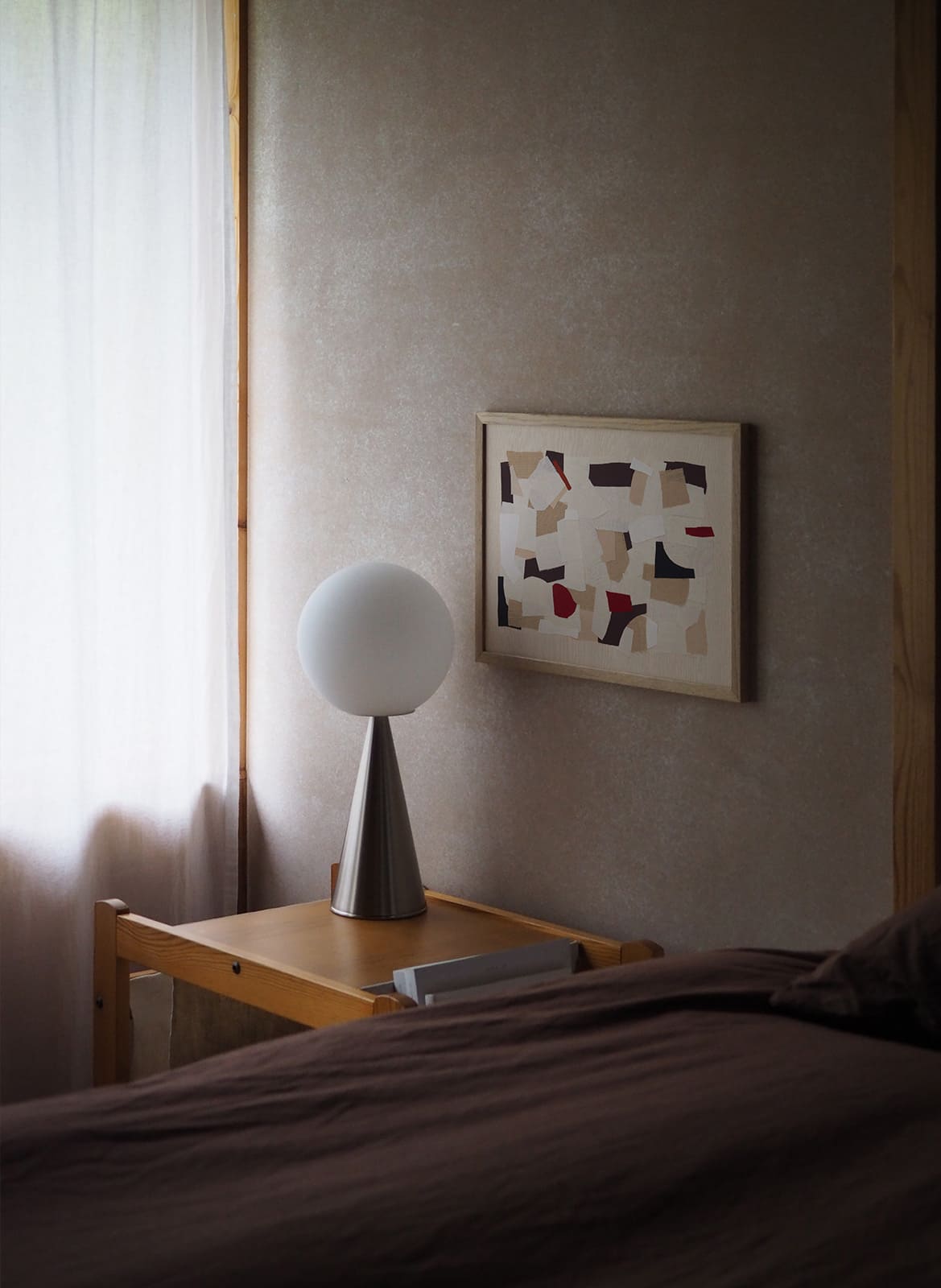 Framed minimalistic poster hanging above a bed by Atelier Cph