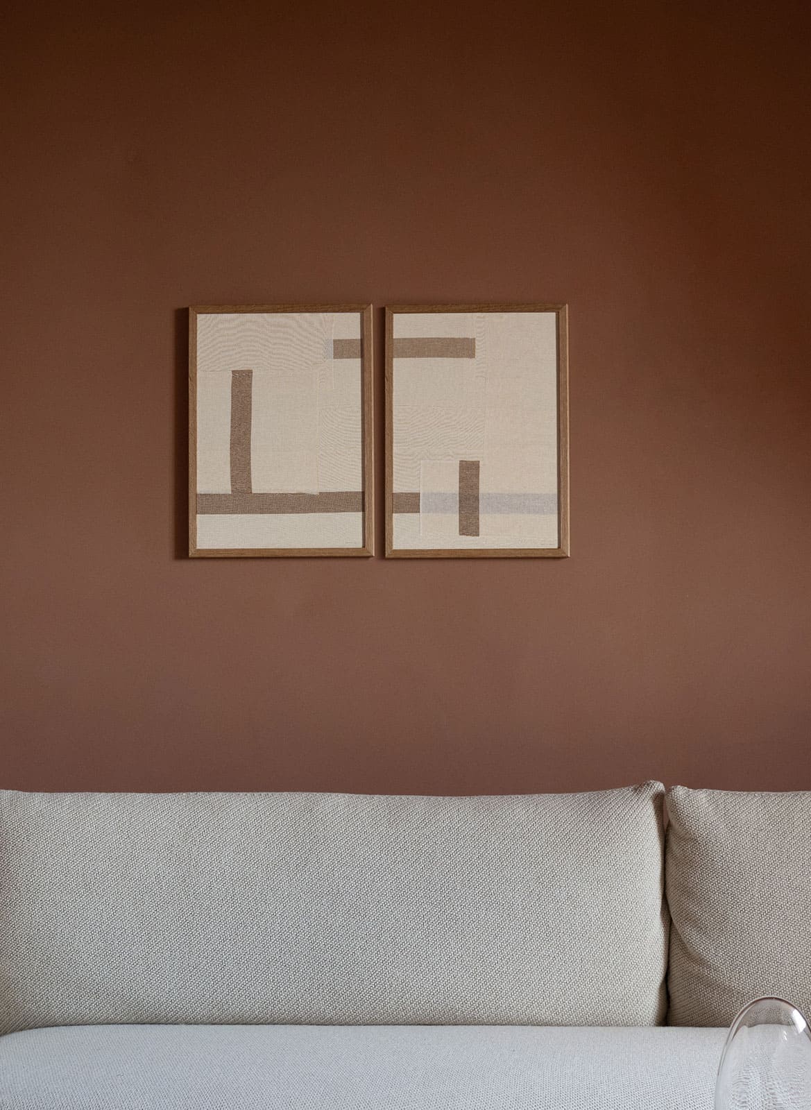 Fabric structured posters hanging above a couch by atelier cph