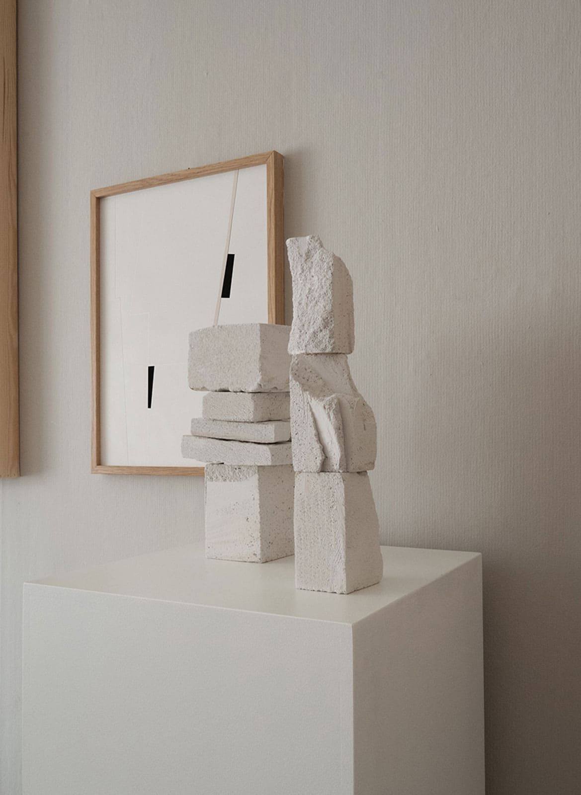  2 sculptures and a framed art piece hanging behind it by atelier cph